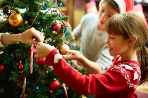 Lille pige hjælper med at pyntejuletræet - jul