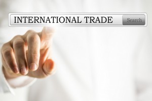 Hånd peger på skilt med teksten international trade - international handel
