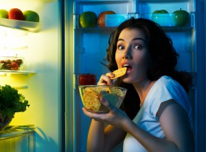 Kvinde bliver overrasket mens hun snacker fra køleskabet