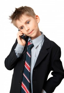 Dreng i jakkesæt med slips taler i mobiltelefon