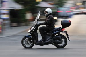 Mand på scooter med beskyttelseshjelm